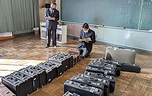 小学校で使われず眠っている管楽器の状態を調査点検する楽器専門店のスタッフ