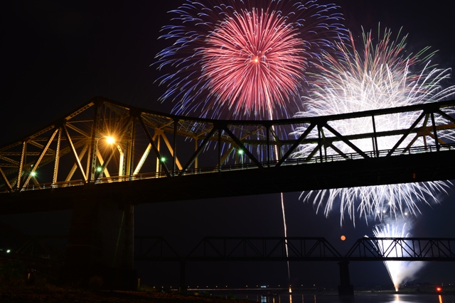 鹿島橋を浮かび上がらせる花火の光