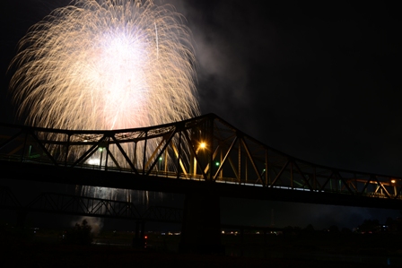 花火の光で浮かび上がる橋のシルエット