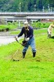 二俣川の岸辺の草刈りをする人