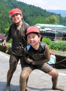 泥まみれではしゃぐ児童たち