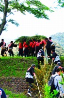 竜を肩に担いで坂を駆け上がる人たち