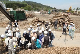 山田町での空間線量率の測定（後方は破砕前の柱材・角材）