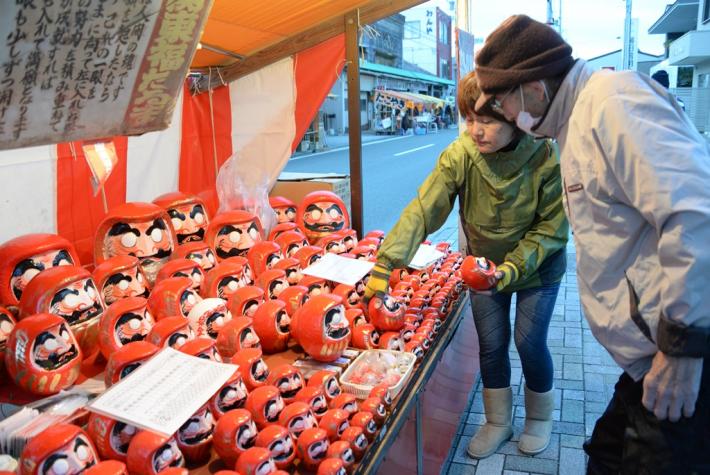 酉の市で、だるまを買う来場客