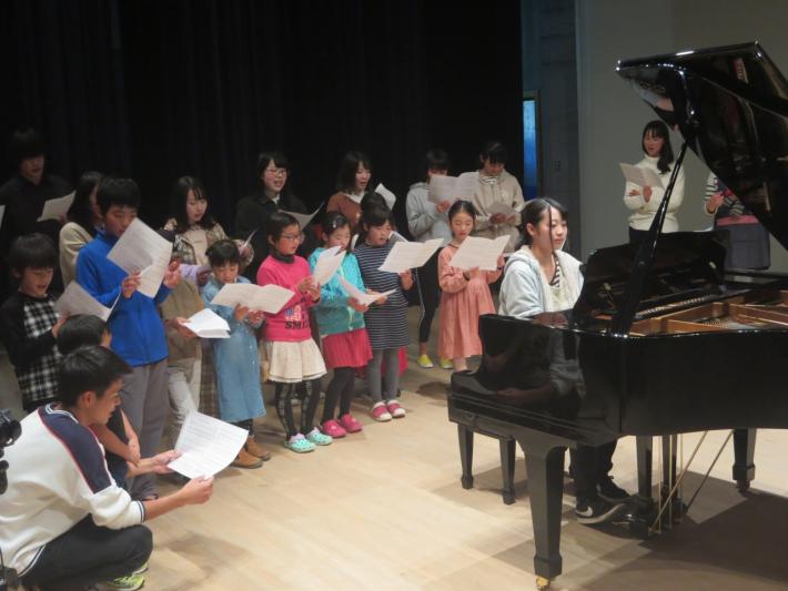 ピアノの伴奏に合わせて歌う子供たち