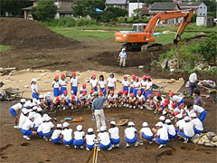 輪になって説明を聞く小学生